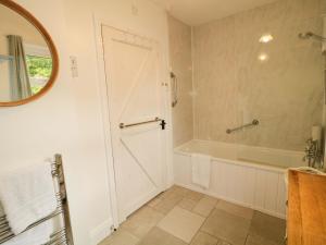 a bathroom with a tub and a shower and a door at Rosslare Cottage in Broughshane +21 photos