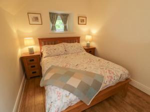 a bedroom with a bed with two night stands and two lamps at Rosslare Cottage in Broughshane