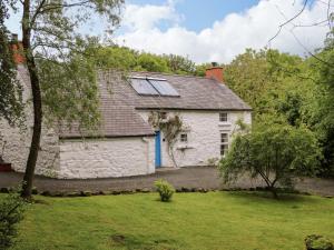 an old stone house with a blue door at Rosslare Cottage in Broughshane