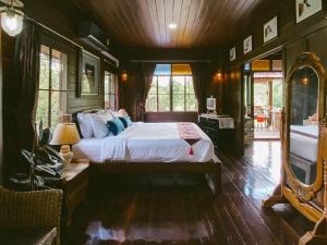 a bedroom with a bed and a mirror in it at Rommai Villa Chiang Rai in Ban Pa Sang (1)