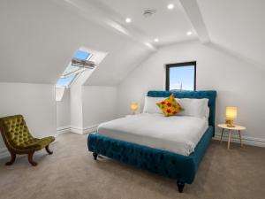a bedroom with a blue bed and a chair at Sweet Garden in Ballyconneely