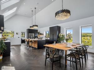 a kitchen and dining room with a wooden table and chairs at Sweet Garden in Ballyconneely
