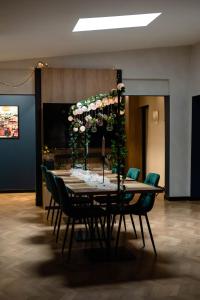 a dining room table with chairs and flowers on it at Ajncla in Katowice