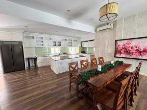 a large kitchen with a wooden table and chairs at An Nhien Mercury Villa & Resort in Phú Quốc