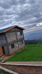a brick building on top of a grassy hill at Propost place in Kijabe