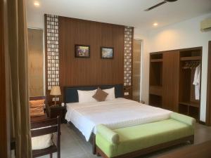 a bedroom with a white bed and a green bench at An Nhien Mercury Villa & Resort in Phú Quốc +51 photos