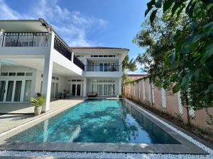 a swimming pool in front of a house at An Nhien Mercury Villa & Resort in Phú Quốc