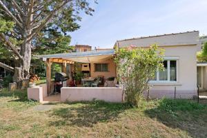 a small white house with a patio and a grill at Gîte rural chez Michel in Soulatgé