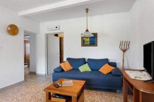 a living room with a blue couch and a table at Gîte rural chez Michel in Soulatgé