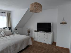 a bedroom with a bed and a tv on a white cabinet at Apartment am Park Anklam in Anklam