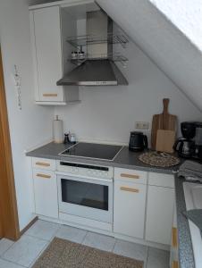 a kitchen with white cabinets and a stove top oven at Apartment am Park Anklam in Anklam