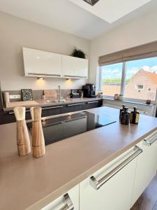 a kitchen with white cabinets and a large window at Maison Bo Luxury Stay in Historic Lemmer in Lemmer