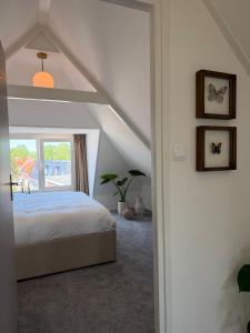 a bedroom with a bed and a window at Maison Bo Luxury Stay in Historic Lemmer in Lemmer