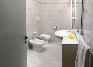 a white bathroom with a toilet and a sink at Villa Maria Giuseppina a San Benedetto del Tronto in Monteprandone