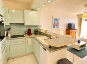 a kitchen with a sink and a counter top at Lagune Azur – Séjour cosy vue mer piscine Wi-Fi in Sète
