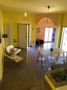 a living room with yellow walls and a table and chairs at Villa Maria Giuseppina a San Benedetto del Tronto in Monteprandone