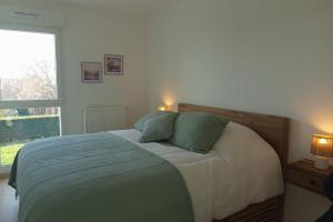 a bedroom with a bed with two green pillows at Spacious and bright 125m2 apartment in Berck in Berck-sur-Mer