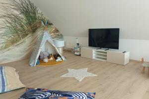 a living room with a play tent and a tv at Spacious and bright 125m2 apartment in Berck in Berck-sur-Mer