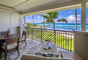 a balcony with a table and a view of the ocean at Villa 317 at Turtle Bay in Kahuku