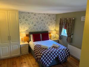 a small bedroom with a bed with red pillows at Professional & Approved Self Catering Short Term Holiday Homes in Maynooth