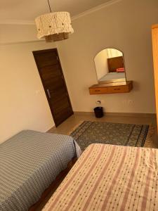 a bedroom with two beds and a mirror at عائلي ومريح in Zāwiyat al ‘Awwāmah +7 photos