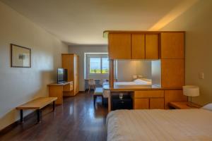 a hotel room with a bedroom with a bed and a desk at Hathor Hotels Mendoza in Mendoza +37 photos