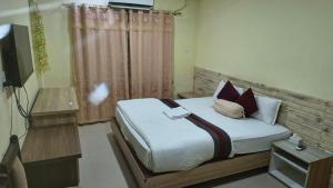 a bedroom with a bed and a television in it at Kutumba Home in Bhairāhawā
