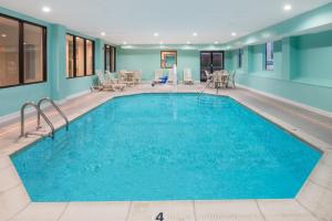 a large pool with blue water in a building at Baymont by Wyndham Georgetown in Georgetown