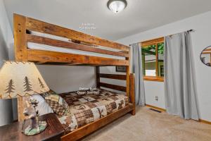 a bedroom with a bunk bed and a desk with a lamp at Tall Pines Lodge in Eagle River WI in Eagle River