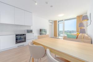 a kitchen and living room with a table and chairs at Apartment TOMI - Olivia Residence in Trnávka