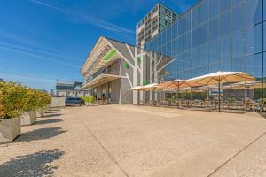 a building with tables and umbrellas in front of it at Apartment TOMI - Olivia Residence in Trnávka