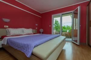 a red bedroom with a large bed and a balcony at Sea Breeze Retreat in Strožanac
