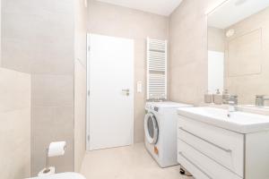 a white bathroom with a washing machine and a sink at Apartment TOMI - Olivia Residence in Trnávka +29 photos