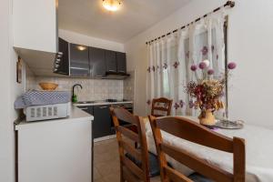a kitchen and dining room with a table and chairs at Sea Breeze Retreat in Strožanac