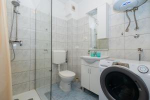 a bathroom with a toilet and a washing machine at Sea Breeze Retreat in Strožanac +21 photos