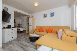 a living room with a couch and a tv at Sea Breeze Retreat in Strožanac
