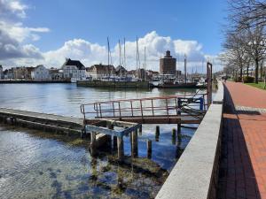 a dock with a bench next to a body of water at Ferienwohnung Oelstorf in Eckernförde +4 photos