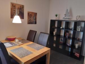a dining room table with chairs and a book shelf at Ferienwohnung Oelstorf in Eckernförde