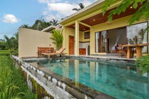 a swimming pool in front of a house at Intan Villa & Suite Ubud in Ubud