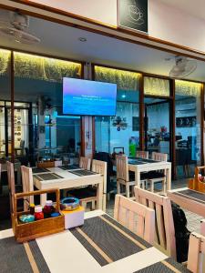 a restaurant with tables and chairs and a large screen at Phuket Inn Patong Hub in Patong Beach