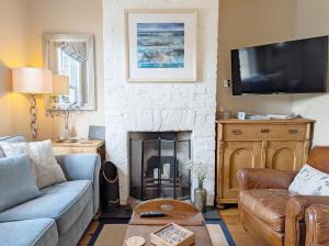 a living room with a couch and a fireplace at Compass Cottage , Emsworth in Emsworth