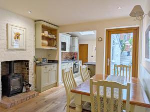 a kitchen and dining room with a table and a fireplace at Compass Cottage , Emsworth in Emsworth