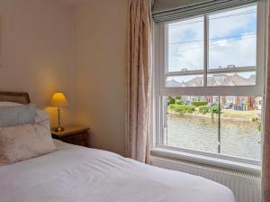 a bedroom with a window with a view of a river at Compass Cottage , Emsworth in Emsworth