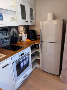 a kitchen with a white refrigerator and white cabinets at Karja Apartment with sauna in Haapsalu
