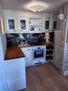 a kitchen with white cabinets and a white refrigerator at Karja Apartment with sauna in Haapsalu