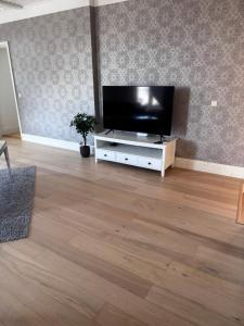 a living room with a flat screen tv on a white cabinet at Karja Apartment with sauna in Haapsalu