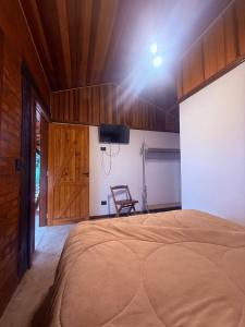 a bedroom with a large bed with a wooden ceiling at Rancho do Ipês in Campos do Jordão