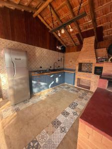 a kitchen with a stainless steel refrigerator in a room at Rancho do Ipês in Campos do Jordão