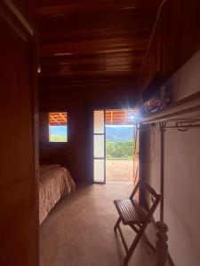 a room with a room with a bed and a window at Rancho do Ipês in Campos do Jordão