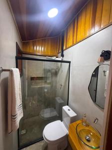 a small bathroom with a toilet and a sink at Rancho do Ipês in Campos do Jordão